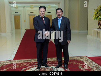 Phnom Penh, Kambodscha. 13. Juli 2016. Luo Baoming (L), Sekretär des Hainan Provinz Komitees der kommunistischen Partei Chinas, schüttelt Hände mit kambodschanischen Ministerpräsidenten Samdech Techo Hun Sen während eine Enthüllung von Direktflügen in Phnom Penh, Kambodscha, 13. Juli 2016. Eine chinesische Airline startet seine Direktflüge von Haikou Stadt der Provinz Süd-China Hainan in Kambodschas Hauptstadt Phnom Penh und Siem Reap vom Ende dieses Monats. © Sovannara/Xinhua/Alamy Live-Nachrichten Stockfoto