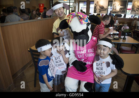 Duluth, GA, USA. 12. Juli 2016. Eine Mutter kämpft um ihre Kinder Position zu erhalten, so dass sie mit einer Chick-Fil-A-Kuh auf Kuh Appreciation Day fotografiert werden können © Robin Rayne Nelson/ZUMA Draht/Alamy Live News Stockfoto