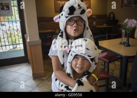 Duluth, GA, USA. 12. Juli 2016. Zwei koreanische Schwestern üben ihre "moos" in einem Chick-Fil-A-Restaurant in Duluth, GA auf Kuh Appreciation Day. © Robin Rayne Nelson/ZUMA Draht/Alamy Live-Nachrichten Stockfoto