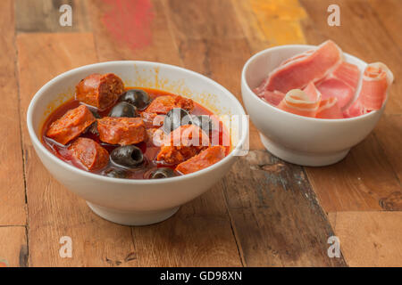 Traditionelle spanische Tapa: Chorizo al Cava mit schwarzen Oliven Stockfoto