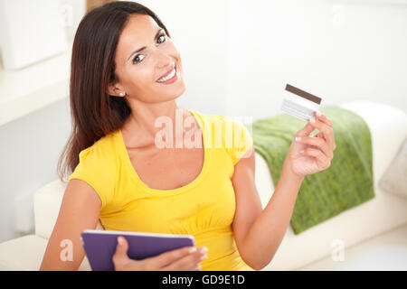 Attraktive Frau mit einer Kreditkarte beim Blick auf die Kamera und lächelnd Stockfoto