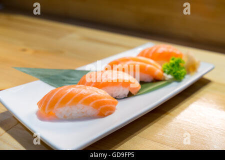 Lachs Sushi, japanische Küche köstliches Menü, serviert auf hölzernen Theke Tisch Stockfoto