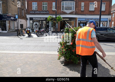 Ein Rat Arbeiter Wasser Blumen auf der High Street Brentwood einer englischen Kleinstadt in Essex Stockfoto