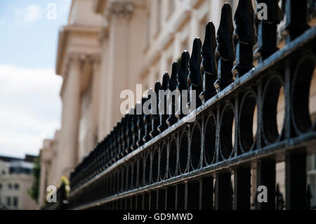 Eine Nahaufnahme Bild mit flachen Fokus zeigt einige schwarze Eisengitter vor einem großen historischen Gebäude in London. Stockfoto
