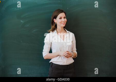 Frau Zeigefinger am leeren Brett. Lehrerin mit dem Finger auf einem leeren Brett. Student an der Tafel steht. Business-Frau präsentiert die Idee in den Vorstand. Mädchen in der Schule. Stockfoto