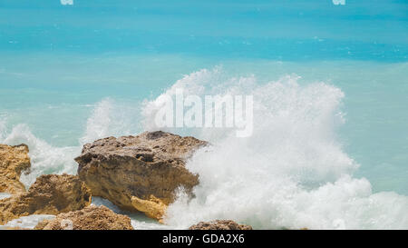Meer Wasser spritzt auf den Felsen in der Nähe. Malerische Aussicht auf Wellen brechen sich an Felsen am Sommertag. Stockfoto