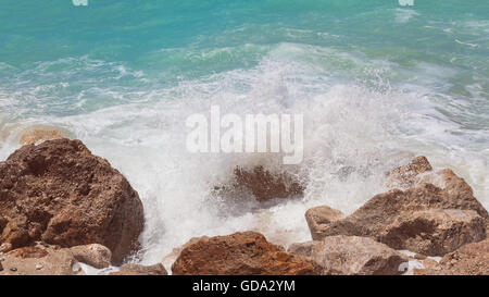 Meer Wasser spritzt auf den Felsen in der Nähe. Malerische Aussicht auf Wellen brechen sich an Felsen am Sommertag. Vintage getönten Bild Stockfoto