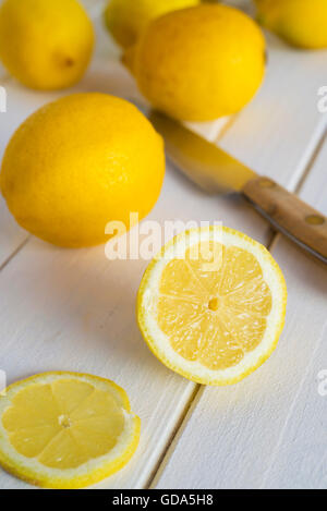 Frische Zitronen und Messer auf Holz Hintergrund Stockfoto