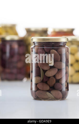 Eingelegte Kalamata Oliven Jar mit anderen Gurken Gläser im Hintergrund Stockfoto