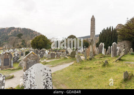 Irland, County Wicklow, Fluss in Glendalough (Tal der zwei Seen) ist ein Tal im irischen Wicklow Mountains. Kloster mit Rundturm Stockfoto