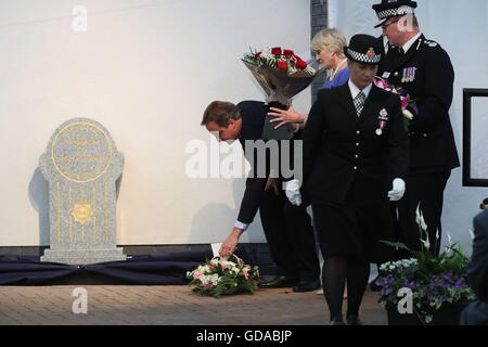 Geraldine Winner, Vorsitzender der Polizei Memorial Trust, Uhren-ehemaliger Premierminister David Cameron legen Blumen auf einem Gedenkstein in Mottram, Tameside, enthüllte Pc Fiona Bone, 32, und Pc Nicola Hughes, 23, eine Pistole und Handgranate Angriff im September 2012 ermordeten zu Ehren. Stockfoto