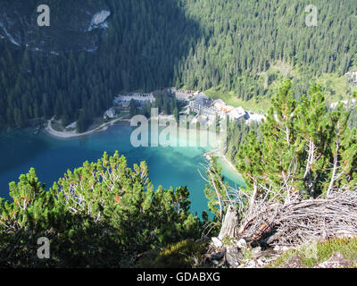 Italien, Trentino-Alto Adige, Bolzano, Blick von oben auf die Häuser am Wildsee, Wandern Sie zu den Herrenstein, Braies Wildsee schimmert blau in den tiefen Stockfoto