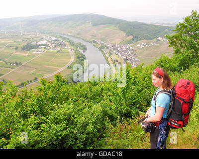 Deutschland, Rheinland-Pfalz, Zeltingen-Rachtig, Steig auf die Mosel, Wanderer genießt den Blick auf das Flusstal und Weinbergen, in der Rückseite Ürzig Stockfoto