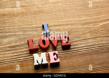 Ich liebe ME-Wort aus bunten Buchstaben auf hölzernen Hintergrundfarbe warm gemacht Stockfoto