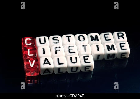 CLV Customer Lifetime Value geschrieben am Würfel auf schwarzem Hintergrund Stockfoto