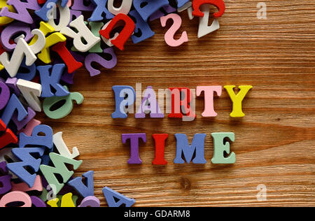Partyzeit - Wörter aus bunten Buchstaben auf hölzernen Hintergrund gemacht Stockfoto