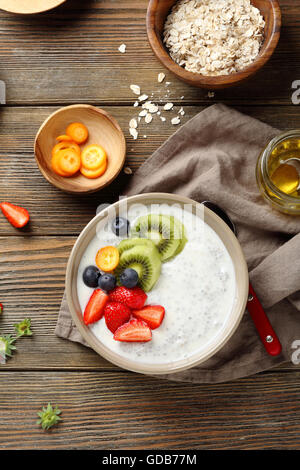 Chia Samen Milchbrei mit Früchten auf hölzernen Hintergrund Stockfoto