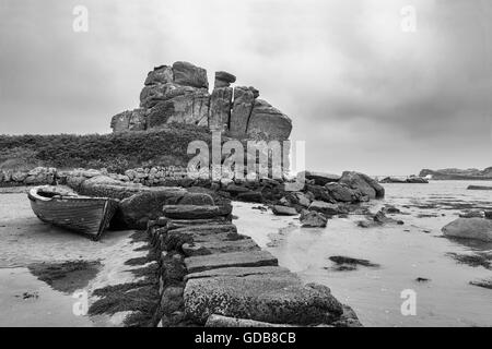 Verlassene Boot durch einen Steg und Dick's Carn (aka der geladenen Camel), Porth Hellick, St. Mary's, Isle of Scilly, UK. Schwarz und Weiss Stockfoto