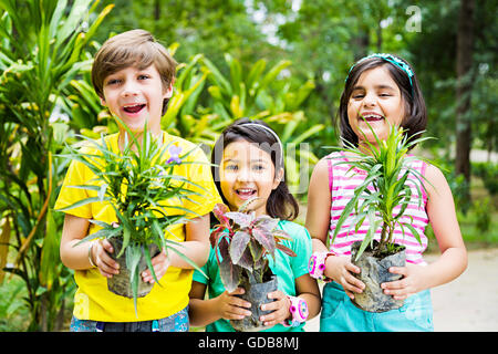 3 Indianer Kinder Freunde Park hält Topfpflanzen Pflanze Stockfoto