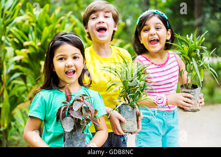 3 Indianer Kinder Freunde Park hält Topfpflanzen Pflanze Stockfoto