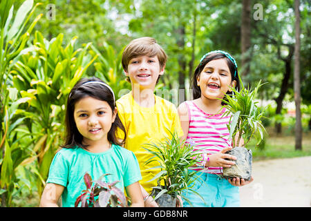 3 Indianer Kinder Freunde Park hält Topfpflanzen Pflanze Stockfoto