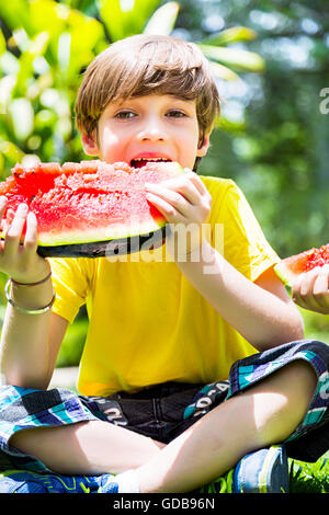 1 Kind Indianerjunge Parken Wassermelone essen Obst Stockfoto
