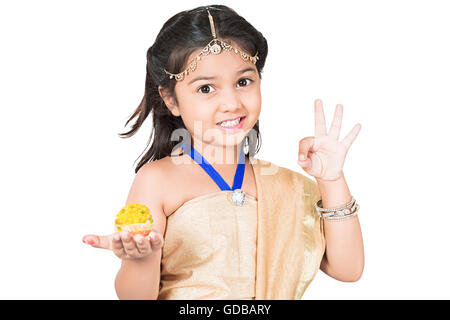 1 Kind Inderin Diwali Festival Palm Süßigkeiten Laddu zeigen Stockfoto