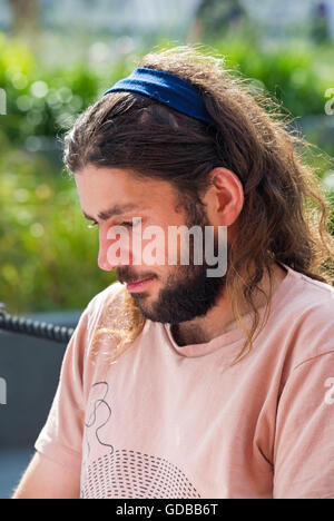 Bärtiger Mann zum Entspannen in der Sonne am Southbank, London im Juli Stockfoto