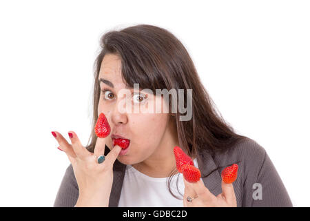 Fette Frau mit Erdbeeren an Fingern und komisch aussehen Stockfoto