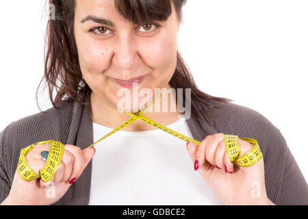 Ziemlich große, dicke Mädchen mit einem Maßband, isoliert auf weiss Stockfoto