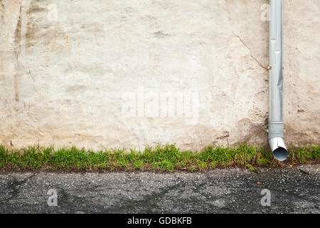 Abstrakte leeren städtischen Hintergrund, alte Hauswand mit Fallrohr in der Nähe von Asphaltstraße Stockfoto