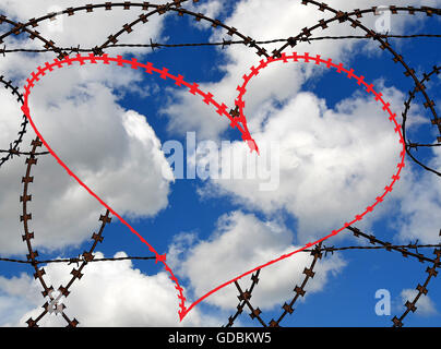 Natürliche Herzform (Digital rot) in einen Stacheldrahtzaun auf Himmelshintergrund. Liebe, Freiheit, Frieden, Hoffnung und Mitgefühl Stockfoto