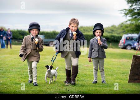 Drei Kinder genießen Eiscreme an der Cutcombe Horse Show und Gymkhana nahe Wheddon Cross, Somerset UK Stockfoto