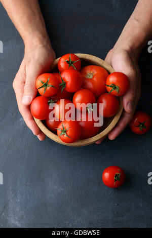 reife Tomaten in Holzschale, Lebensmittel-Hintergrund Stockfoto