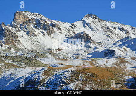 Almhütte in den Schatten gestellt durch die Medispitz (links) und Rotighorn (rechts) in der südlichen Schweiz Alpen oberhalb von Sierre Stockfoto