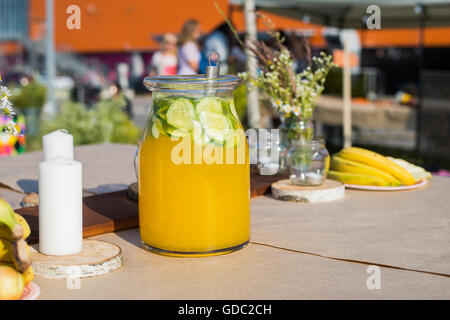 Frisches Kompott, Obst, Kerzen und Blumen auf Holztisch Closeup. Selektiven Fokus. Beutiful Dekoration im Boho-Stil. Stockfoto