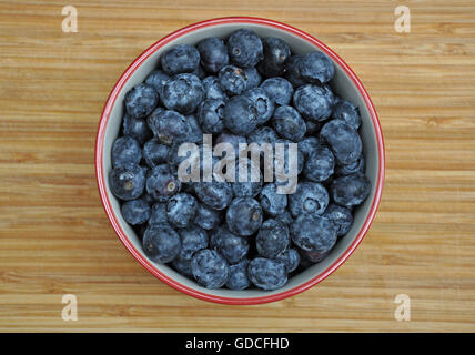 Schüssel gefüllt mit frischen Heidelbeeren auf alten Holzbrett Stockfoto