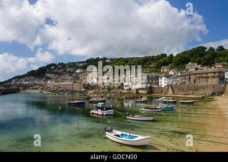 Die kornische Fischerdorf Mousehole mit ihren kleinen Booten in seinem malerischen Hafen und der Stein Fischer hinter sich. Stockfoto