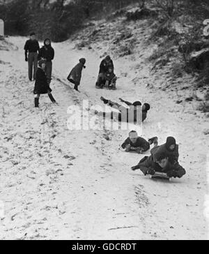 Kinder Rodeln im Schnee in Brighton im kalten Winter des Jahres 1947. Foto von Tony Henshaw Stockfoto