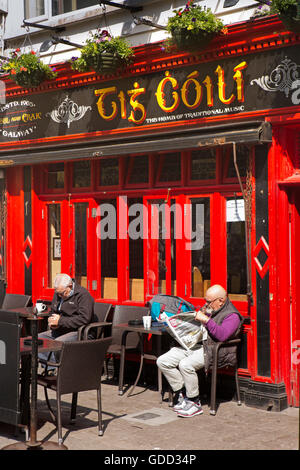 Irland, Co. Galway, Galway, Guard Hauptstraße, Tis Coili, traditionelle Musik Bar Kunden Entspannung im Sonnenschein Stockfoto