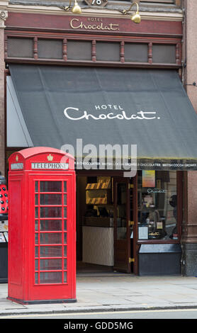 Rote Telefonzelle vor dem Hotel Chocolat, Strand, London UK im Juli Stockfoto