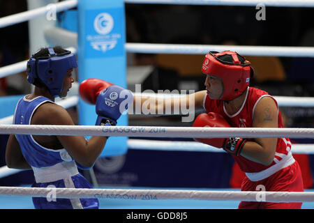 Laishram Devi von Indien (rot) konkurriert gegen Maria Machongua von Mosambik (blau) im Wettbewerb der Frauen Halbfinale geringes Gewicht Boxen (57-60kg) an die Commonwealth-Spiele 2014 in Glasgow. Laishram Devi von Indien ging auf gewinnen den Kampf. Stockfoto