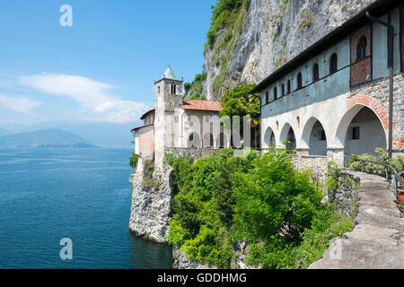 Eremo di Santa Caterina del Sasso und den Lago Maggiore mit Berg an einem sonnigen Tag in der Lombardei, Italien. Stockfoto