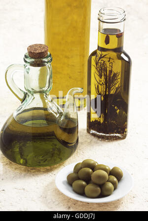 OLIVENÖLFLASCHE, und grüne Oliven Olea europaea Stockfoto