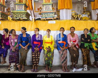 15. Juli 2016 - warten Ubud, Bali, Indonesien - Frauen in Gianyar das Dorf Masse Einäscherung zu starten. Die Bildnisse, die die Völker wird eingeäschert zu vertreten, werden in einer langen Prozession zum Friedhof gebracht und dann verbrannt. Die meisten Menschen auf Bali sind Hindus. Traditionelle Feuerbestattungen in Bali sind sehr teuer, so dass die Gemeinden in der Regel eine Masse Einäscherung etwa alle fünf Jahre halten. Die meisten der Masse Feuerbestattungen in Bali finden Ende Juni oder Anfang Juli statt. Gianyar, einem kleinen Dorf ca. 30 Minuten von Ubud, statt ihre Dorf breite Feuerbestattung Freitag. Die Gemeinschaft breite Masse Einäscherung ich Stockfoto