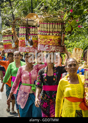 Ubud, Bali, Indonesien. 15. Juli 2016. Frauen tragen Angebote mit den Bildnissen des Friedhofs in Gianyar verbrannt werden. Die meisten Menschen auf Bali sind Hindus. Traditionelle Feuerbestattungen in Bali sind sehr teuer, so dass die Gemeinden in der Regel eine Masse Einäscherung etwa alle fünf Jahre halten. Die meisten der Masse Feuerbestattungen in Bali finden Ende Juni oder Anfang Juli statt. Gianyar, einem kleinen Dorf ca. 30 Minuten von Ubud, statt ihre Dorf breite Feuerbestattung Freitag. Die Gemeinschaft breite Masse Einäscherung in Ubud ist Samstag. © Jack Kurtz/ZUMA Draht/Alamy Live-Nachrichten Stockfoto