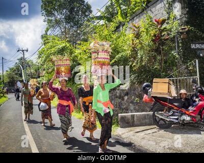 Ubud, Bali, Indonesien. 15. Juli 2016. Frauen tragen Angebote mit den Bildnissen des Friedhofs in Gianyar verbrannt werden. Die meisten Menschen auf Bali sind Hindus. Traditionelle Feuerbestattungen in Bali sind sehr teuer, so dass die Gemeinden in der Regel eine Masse Einäscherung etwa alle fünf Jahre halten. Die meisten der Masse Feuerbestattungen in Bali finden Ende Juni oder Anfang Juli statt. Gianyar, einem kleinen Dorf ca. 30 Minuten von Ubud, statt ihre Dorf breite Feuerbestattung Freitag. Die Gemeinschaft breite Masse Einäscherung in Ubud ist Samstag. © Jack Kurtz/ZUMA Draht/Alamy Live-Nachrichten Stockfoto