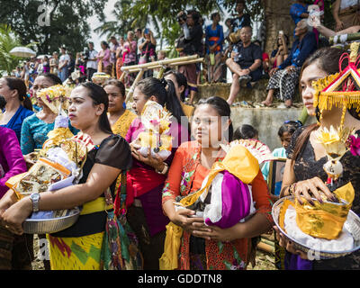 Ubud, Bali, Indonesien. 15. Juli 2016. Frauen warten auf Angebote in die Sarkophage zu legen, die auch die Bildnisse des verstorbenen während der Gemeinschaft breite Feuerbestattung Gianyar halten. Die meisten Menschen auf Bali sind Hindus. Traditionelle Feuerbestattungen in Bali sind sehr teuer, so dass die Gemeinden in der Regel eine Masse Einäscherung etwa alle fünf Jahre halten. Die meisten der Masse Feuerbestattungen in Bali finden Ende Juni oder Anfang Juli statt. Gianyar, einem kleinen Dorf ca. 30 Minuten von Ubud, statt ihre Dorf breite Feuerbestattung Freitag. Die Gemeinschaft breite Masse Einäscherung in Ubud ist Samstag. (Kredit-Bild: © Jack Kurtz Stockfoto