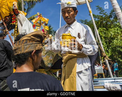 15. Juli 2016 - Ubud, akzeptiert Bali, Indonesien - A Hindupriester Angebote für den Sarkophag von einem Familienmitglied des verstorbenen während der Gemeinschaft breite Feuerbestattung in Gianyar. Die meisten Menschen auf Bali sind Hindus. Traditionelle Feuerbestattungen in Bali sind sehr teuer, so dass die Gemeinden in der Regel eine Masse Einäscherung etwa alle fünf Jahre halten. Die meisten der Masse Feuerbestattungen in Bali finden Ende Juni oder Anfang Juli statt. Gianyar, einem kleinen Dorf ca. 30 Minuten von Ubud, statt ihre Dorf breite Feuerbestattung Freitag. Die Gemeinschaft breite Masse Einäscherung in Ubud ist Samstag. (Kredit-Bild: © Jack Kurtz vi Stockfoto
