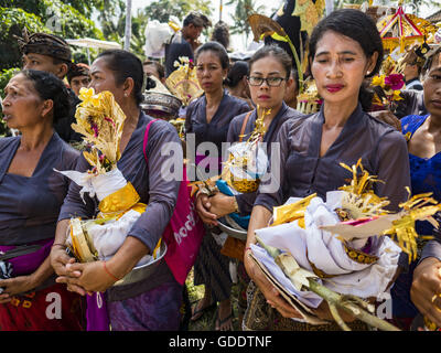 Ubud, Bali, Indonesien. 15. Juli 2016. Frauen warten auf Angebote in die Sarkophage zu legen, die auch die Bildnisse des verstorbenen während der Gemeinschaft breite Feuerbestattung Gianyar halten. Die meisten Menschen auf Bali sind Hindus. Traditionelle Feuerbestattungen in Bali sind sehr teuer, so dass die Gemeinden in der Regel eine Masse Einäscherung etwa alle fünf Jahre halten. Die meisten der Masse Feuerbestattungen in Bali finden Ende Juni oder Anfang Juli statt. Gianyar, einem kleinen Dorf ca. 30 Minuten von Ubud, statt ihre Dorf breite Feuerbestattung Freitag. Die Gemeinschaft breite Masse Einäscherung in Ubud ist Samstag. (Kredit-Bild: © Jack Kurtz Stockfoto